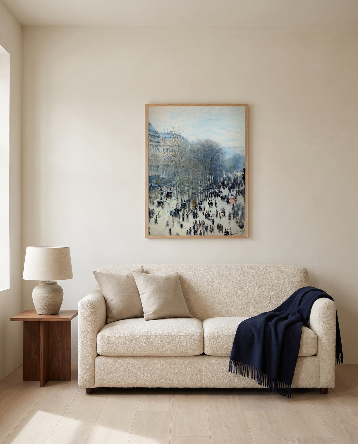 Boulevard des Capucines by Claude Monet framed in natural oak above a cream sofa in a warm living room