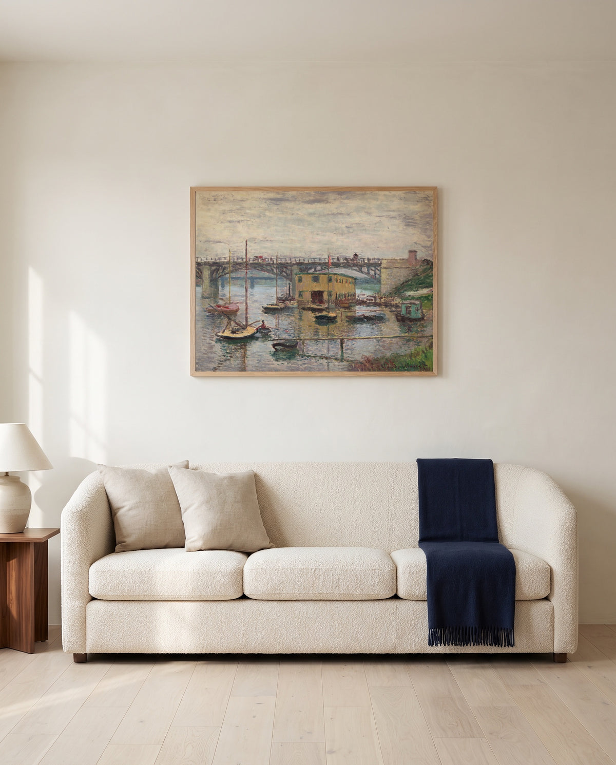 Argenteuil on a Gray Day by Claude Monet framed in natural oak above a cream sofa in a warm living room