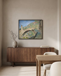 Bridge at Dolceacqua by Claude Monet in a black frame above a walnut sideboard in a dining room