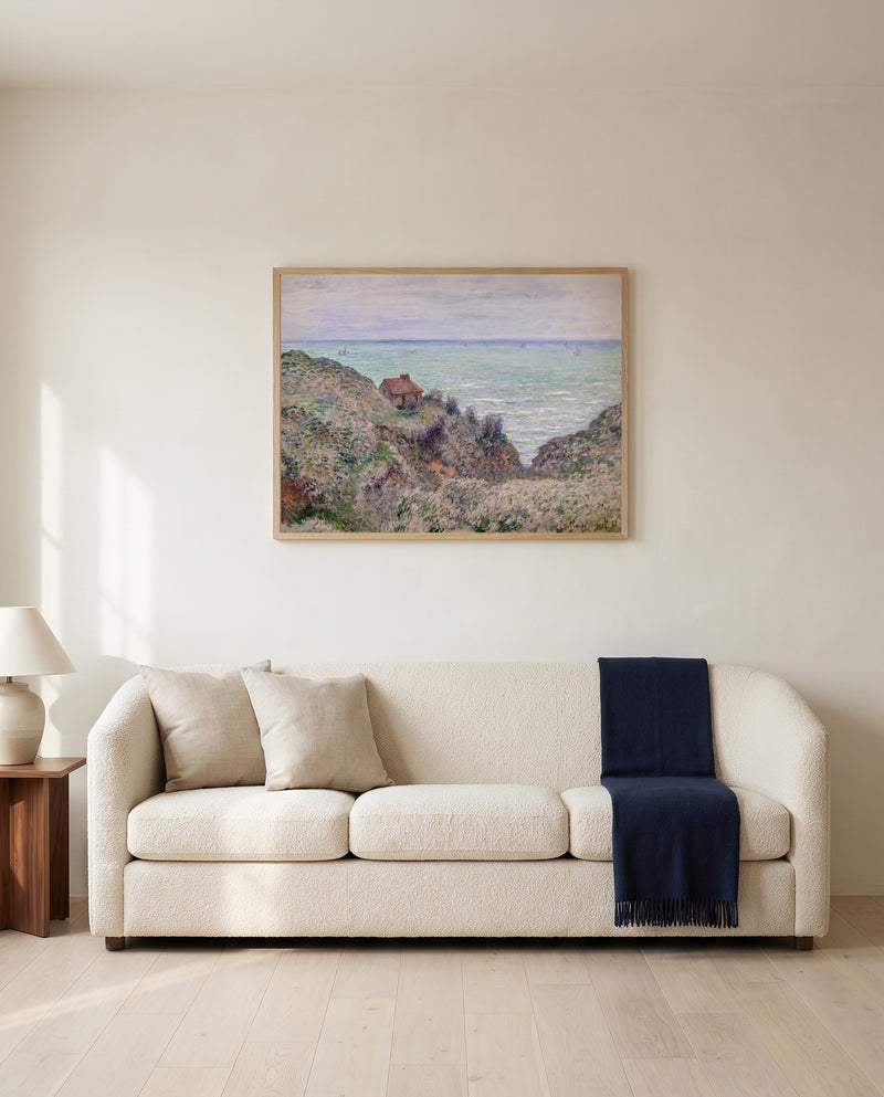 Cabin of the Customs Watch by Claude Monet framed in natural oak above a cream sofa in a warm living room