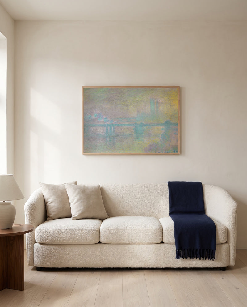 Charing Cross Bridge by Claude Monet framed in natural oak above a cream sofa in a warm living room