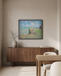 Cliff Walk at Pourville by Claude Monet in a black frame above a walnut sideboard in a dining room