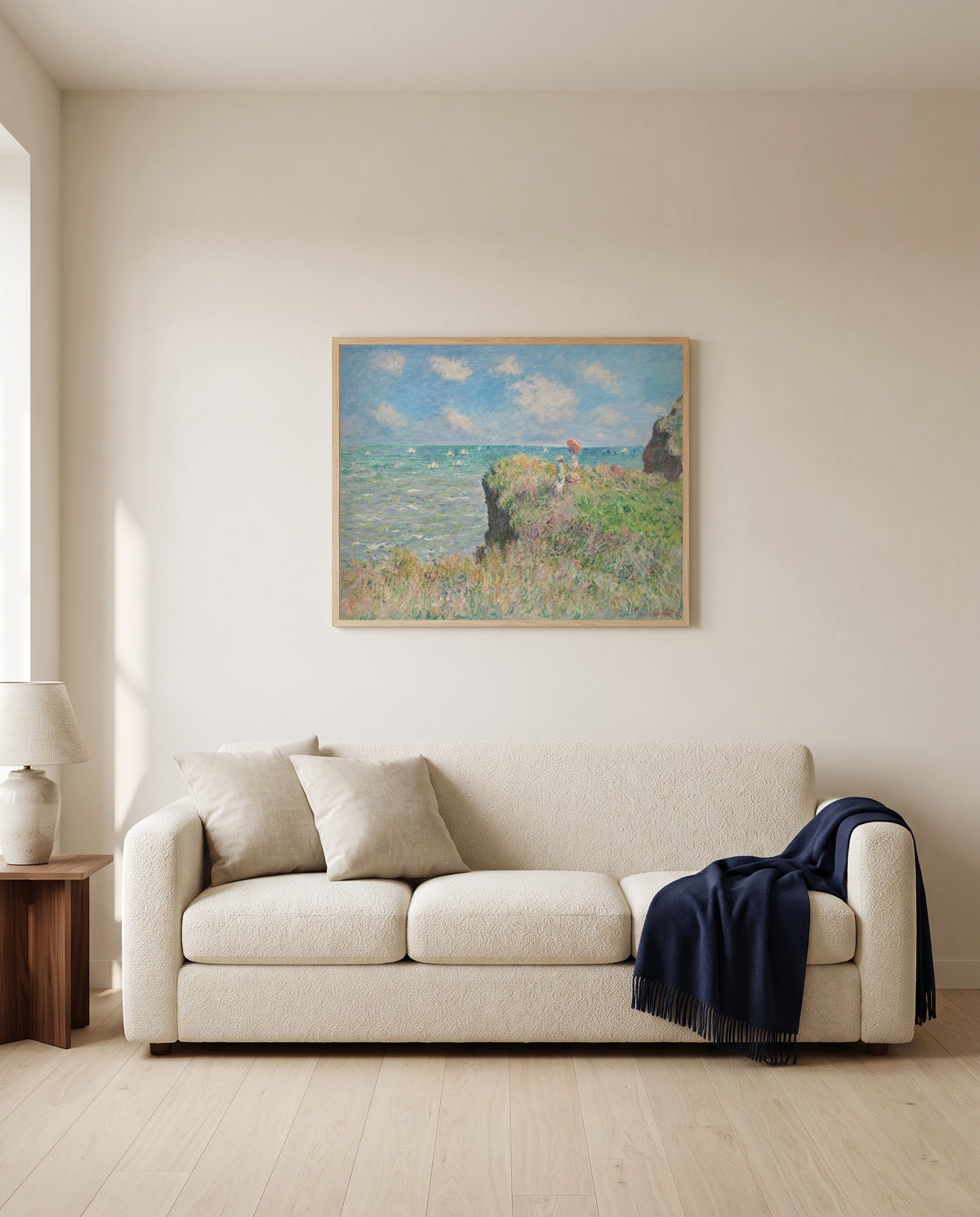 Cliff Walk at Pourville by Claude Monet framed in natural oak above a cream sofa in a warm living room