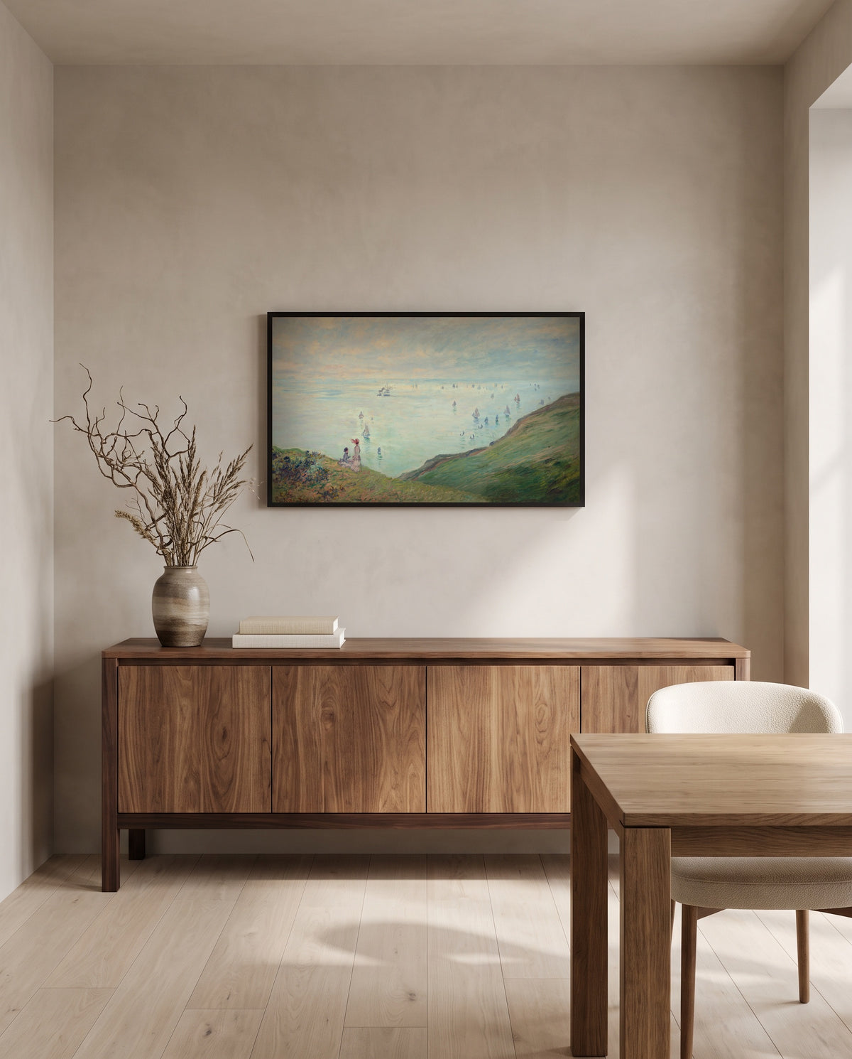 Cliffs at Pourville by Claude Monet in a black frame above a walnut sideboard in a dining room