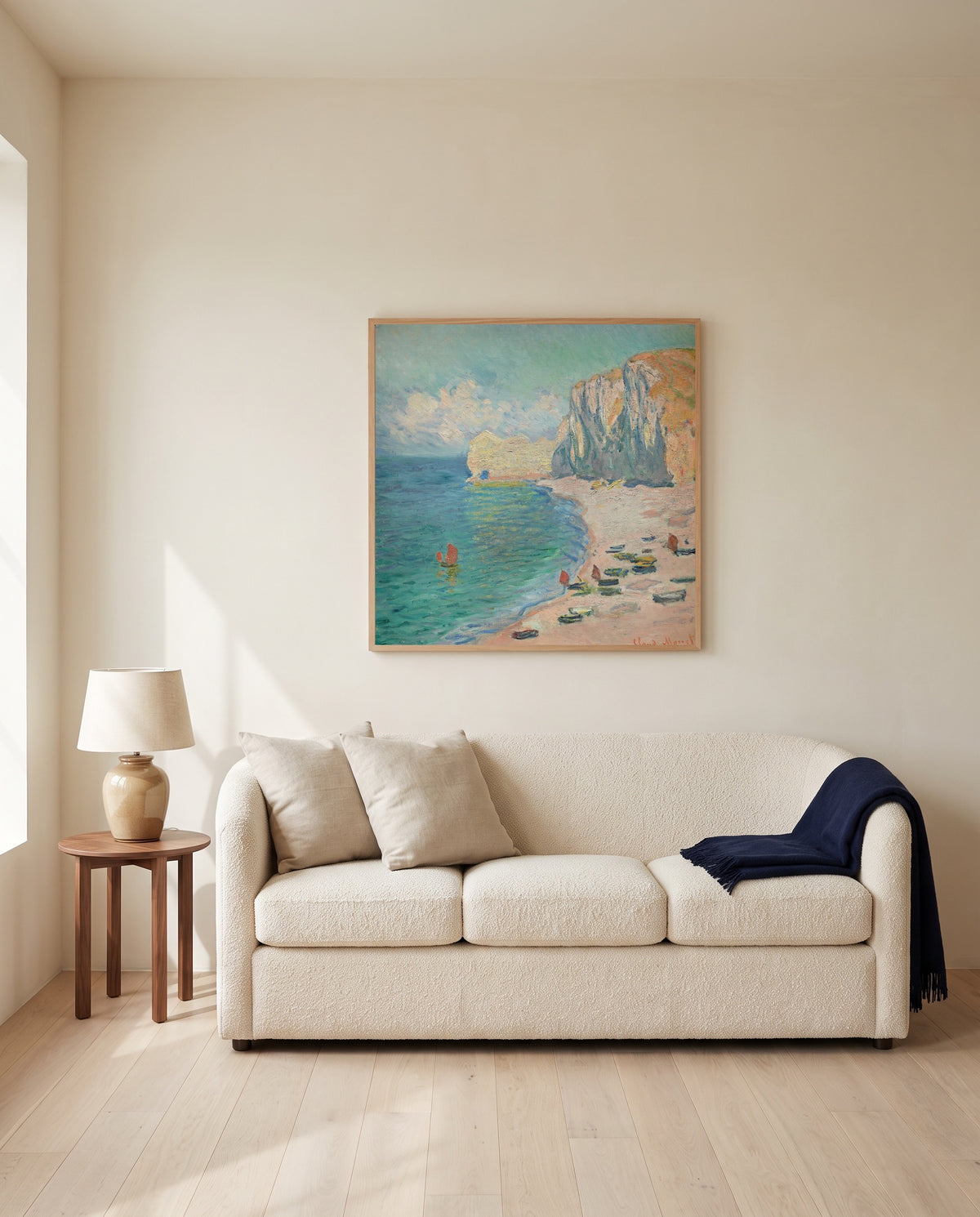 Étretat, Falaise d’Amont by Claude Monet framed in natural oak above a cream sofa in a warm living room