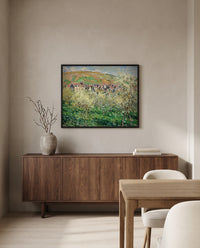 Plum Trees in Blossom by Claude Monet in a black frame above a walnut sideboard in a dining room