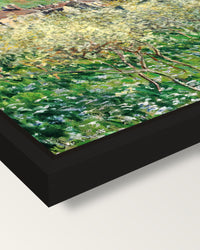 Plum Trees in Blossom by Monet framed canvas, corner close-up: a black floating frame with a shadow gap round the canvas