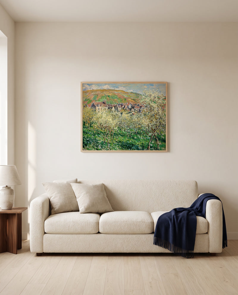 Plum Trees in Blossom by Claude Monet framed in natural oak above a cream sofa in a warm living room