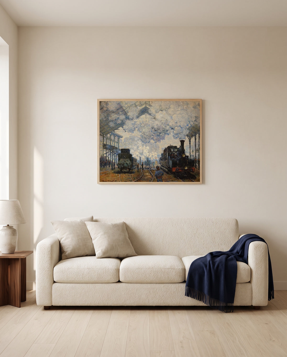 Gare Saint-Lazare by Claude Monet framed in natural oak above a cream sofa in a warm living room
