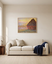 Grainstack (Sunset) by Claude Monet framed in natural oak above a cream sofa in a warm living room