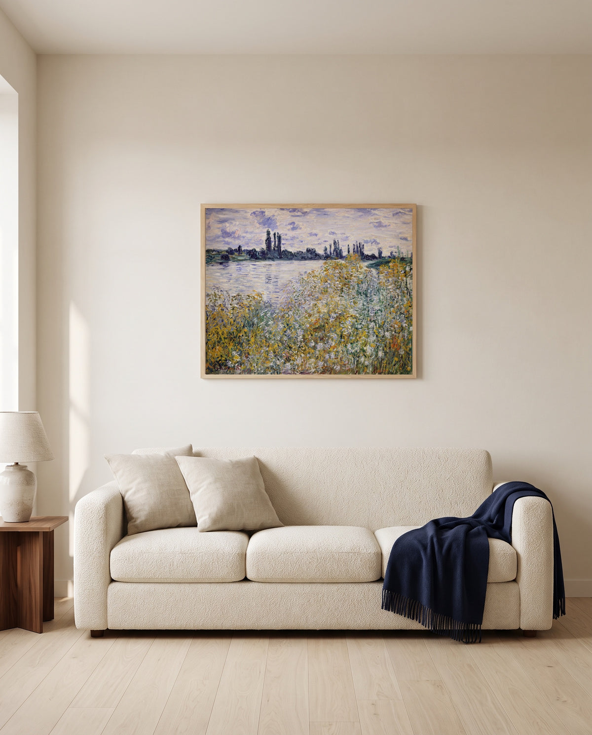 Île aux Fleurs, Vétheuil by Claude Monet framed in natural oak above a cream sofa in a warm living room