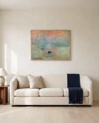 Impression, Sunrise by Claude Monet framed in natural oak above a cream sofa in a warm living room