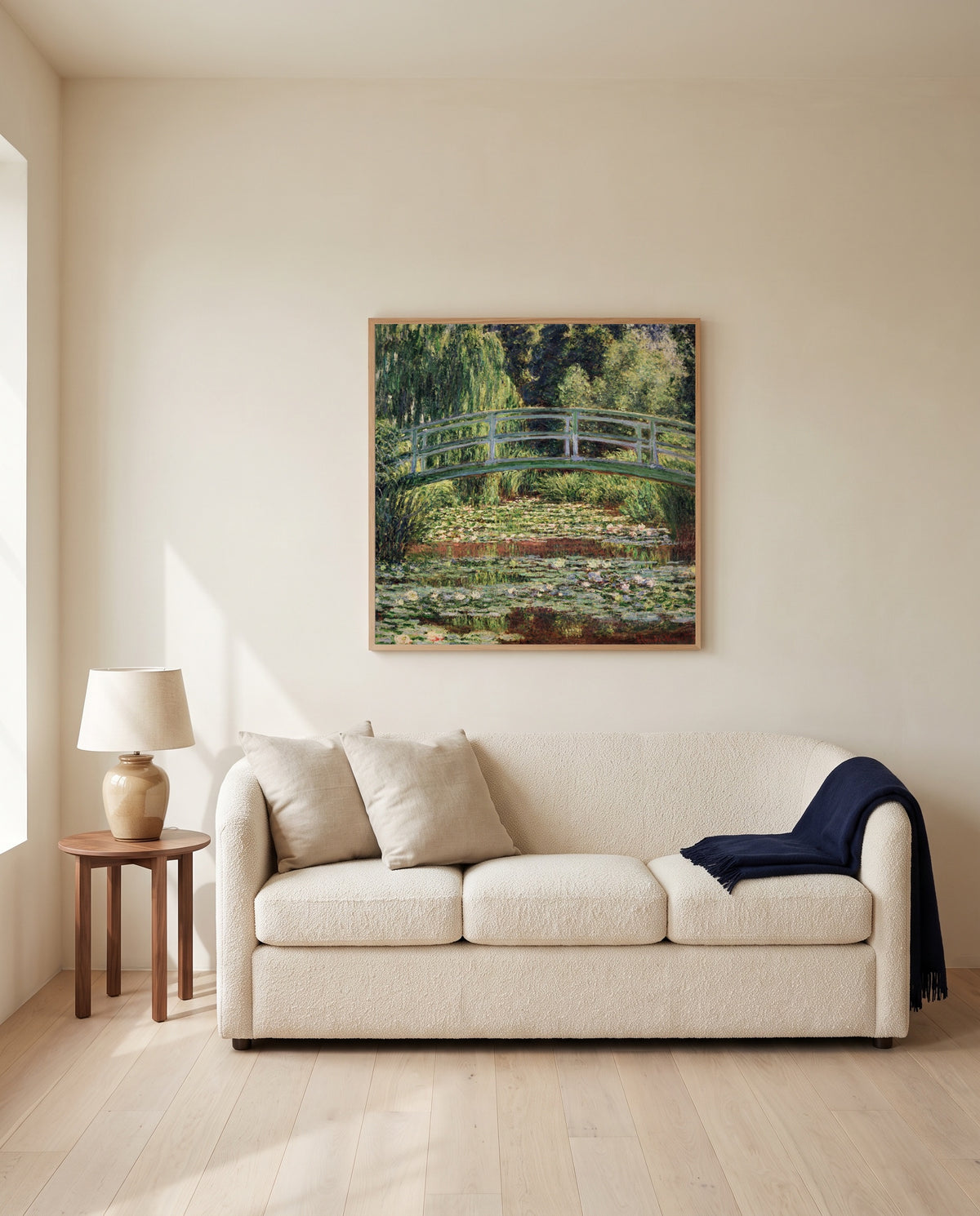 Japanese Footbridge, Giverny by Claude Monet framed in natural oak above a cream sofa in a warm living room