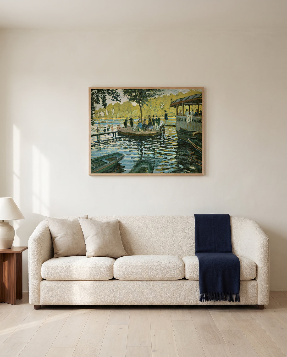 La Grenouillère by Claude Monet framed in natural oak above a cream sofa in a warm living room