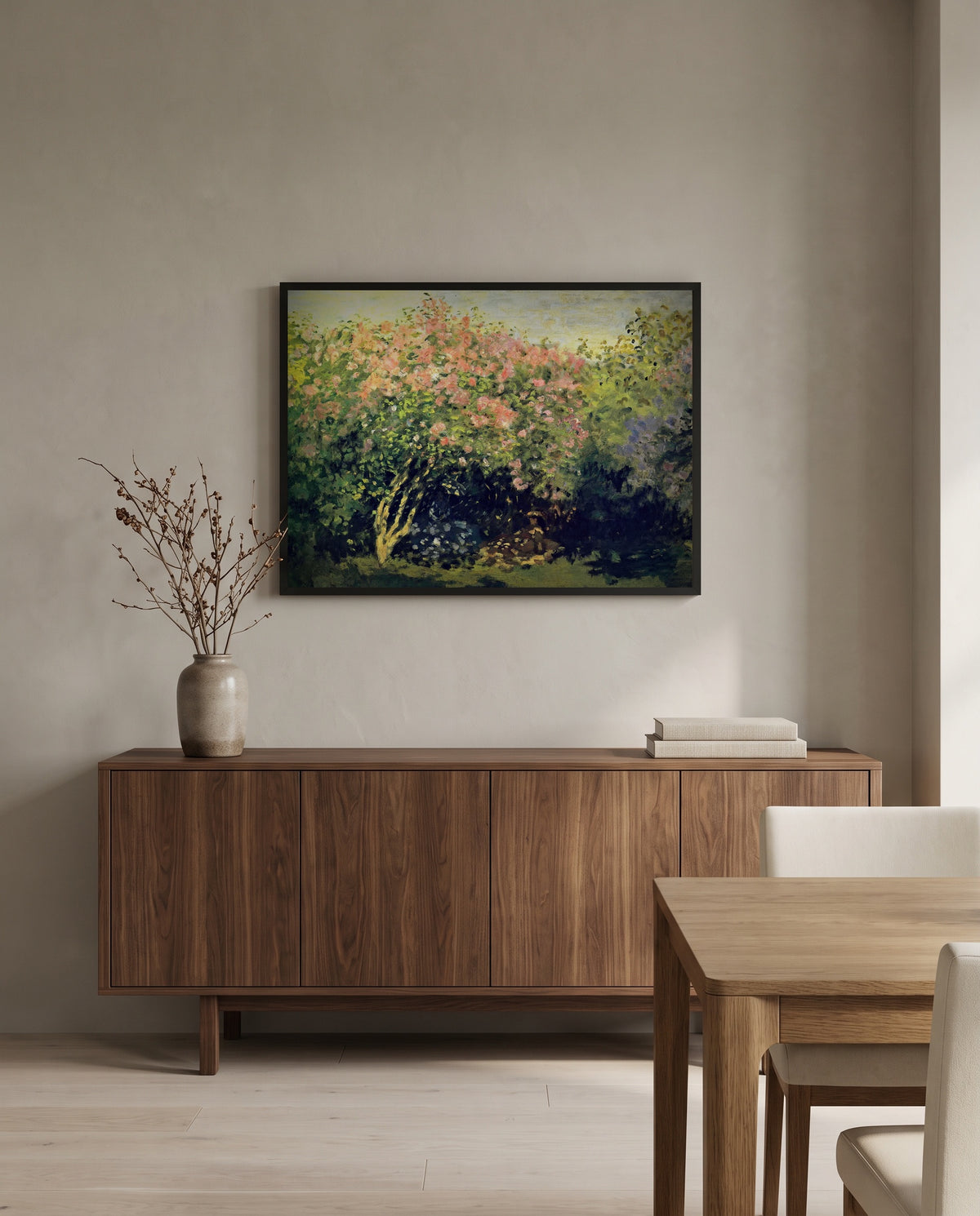 Lilac Bush in the Sun by Claude Monet in a black frame above a walnut sideboard in a dining room