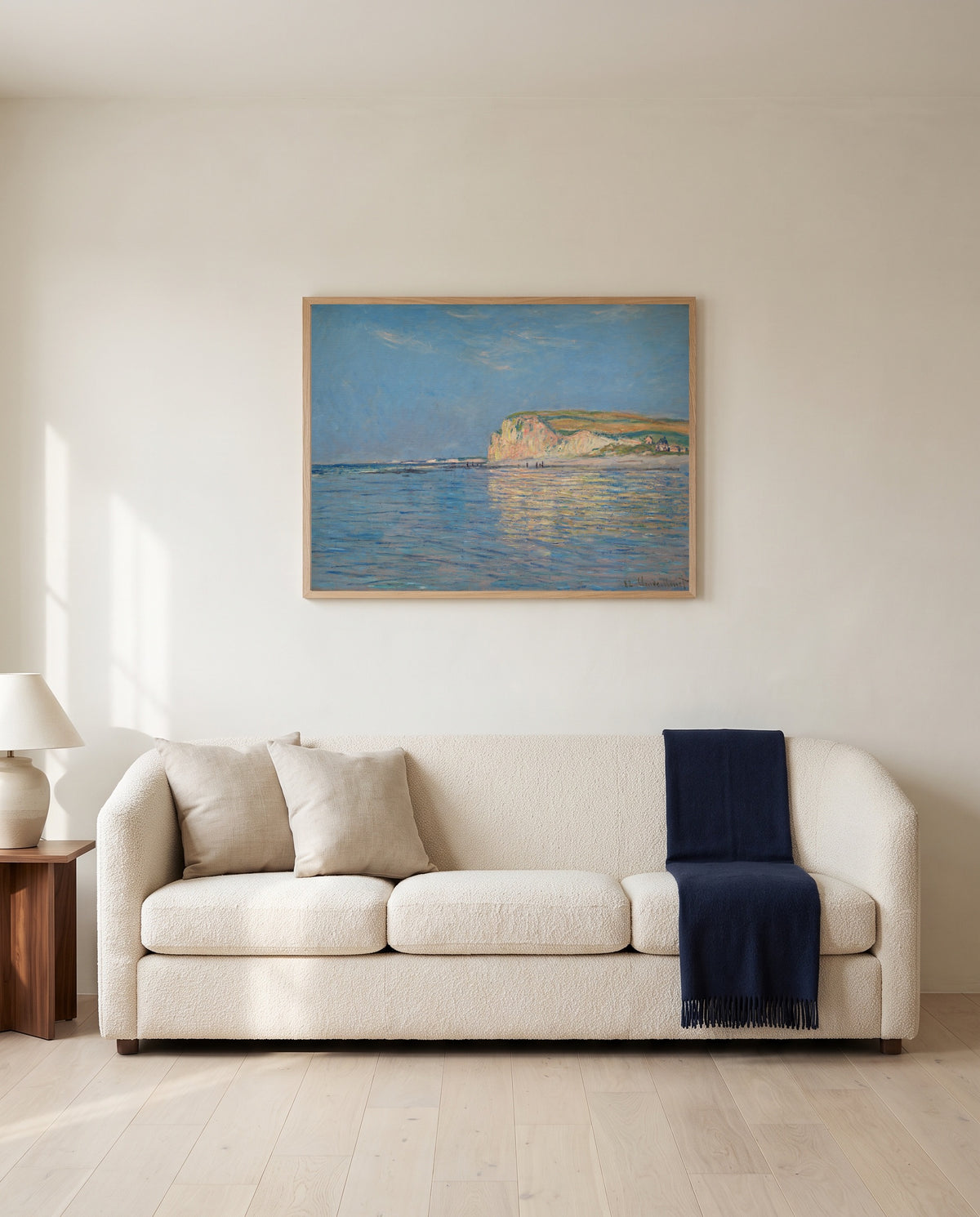 Low Tide at Pourville by Claude Monet framed in natural oak above a cream sofa in a warm living room