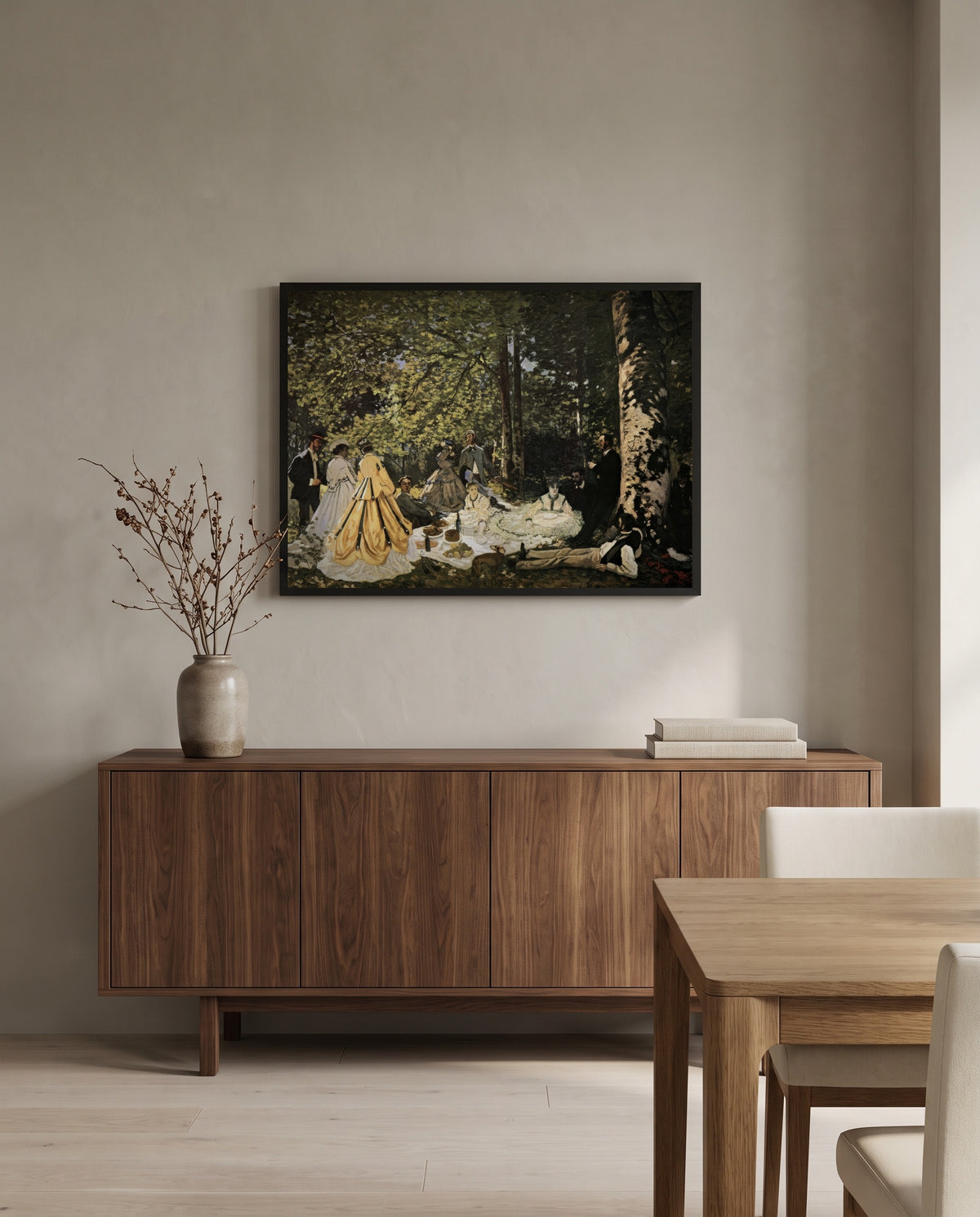 Luncheon on the Grass by Claude Monet in a black frame above a walnut sideboard in a dining room
