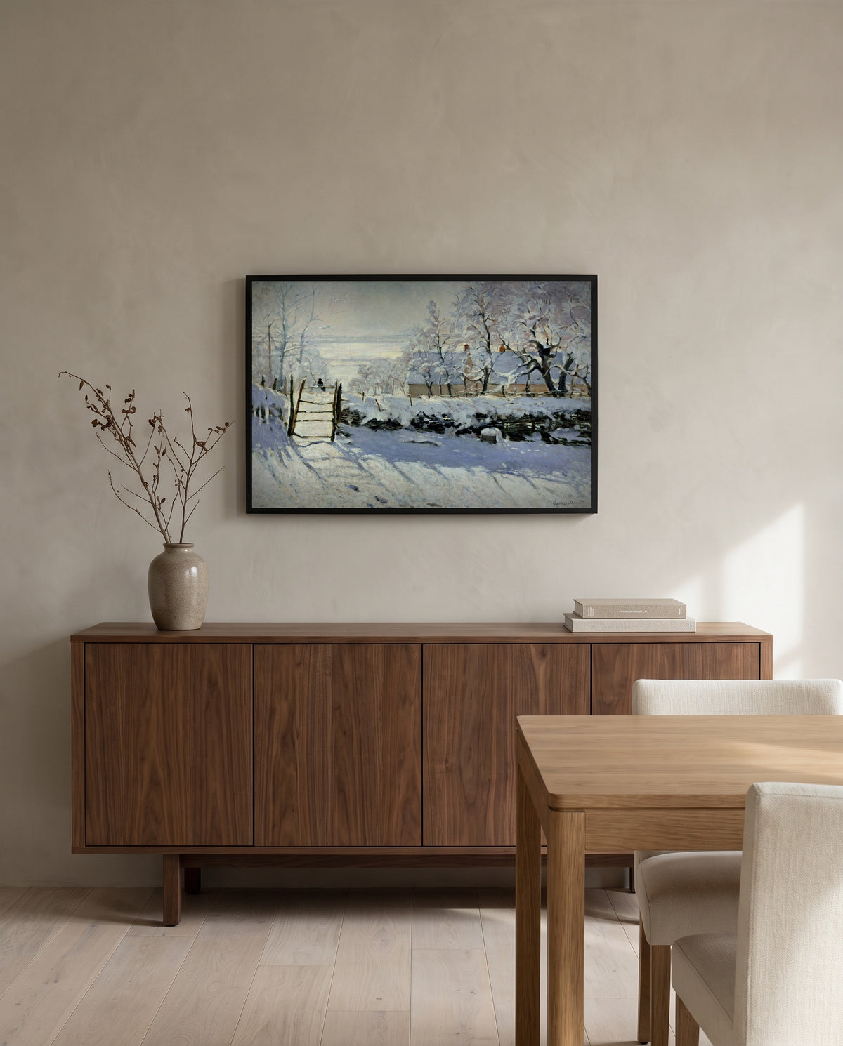 The Magpie by Claude Monet in a black frame above a walnut sideboard in a dining room