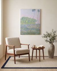 Meadow at Giverny by Claude Monet as a stretched canvas above a linen lounge chair in a reading corner