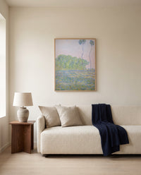 Meadow at Giverny by Claude Monet framed in natural oak above a cream sofa in a warm living room