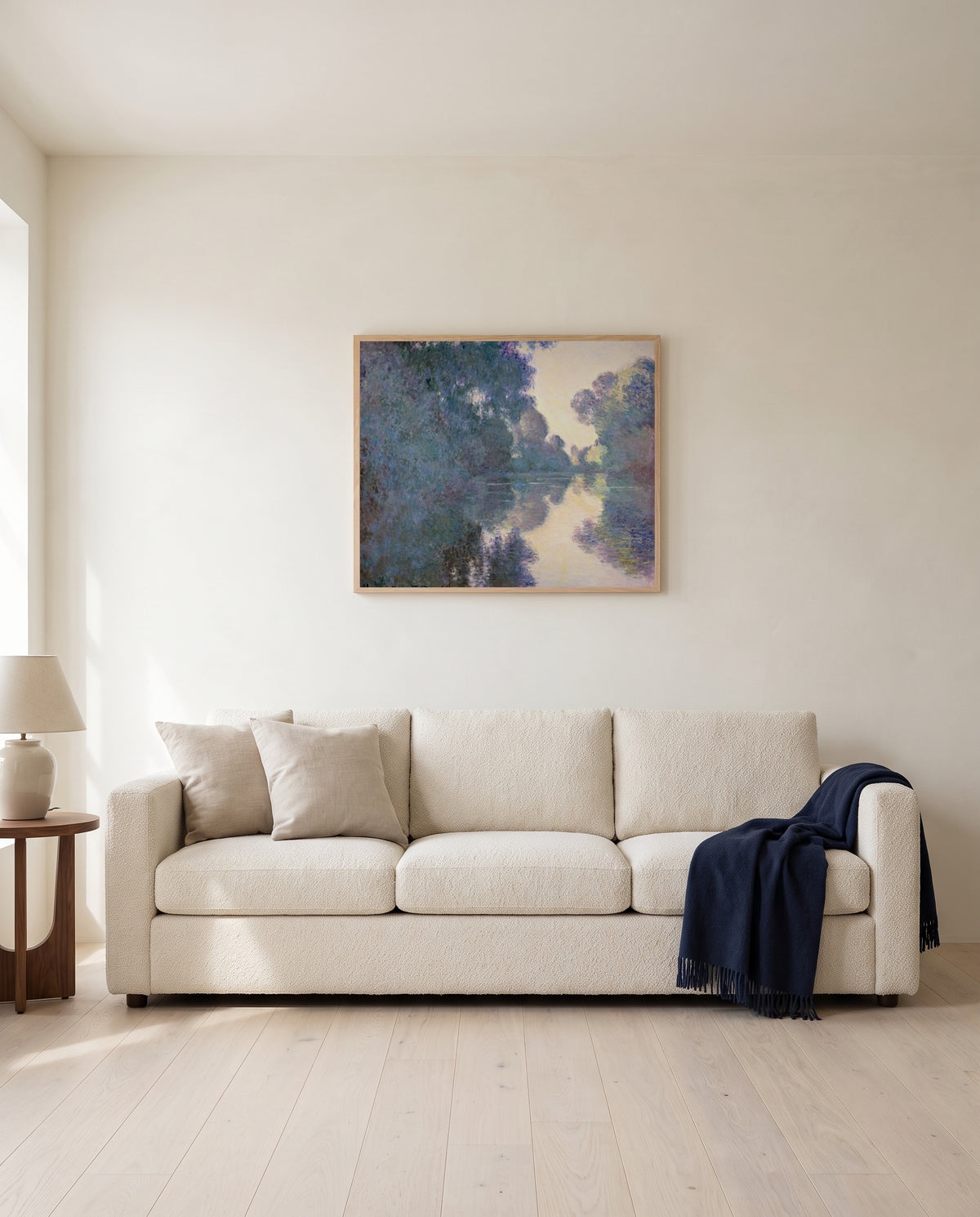 Morning on the Seine by Claude Monet framed in natural oak above a cream sofa in a warm living room