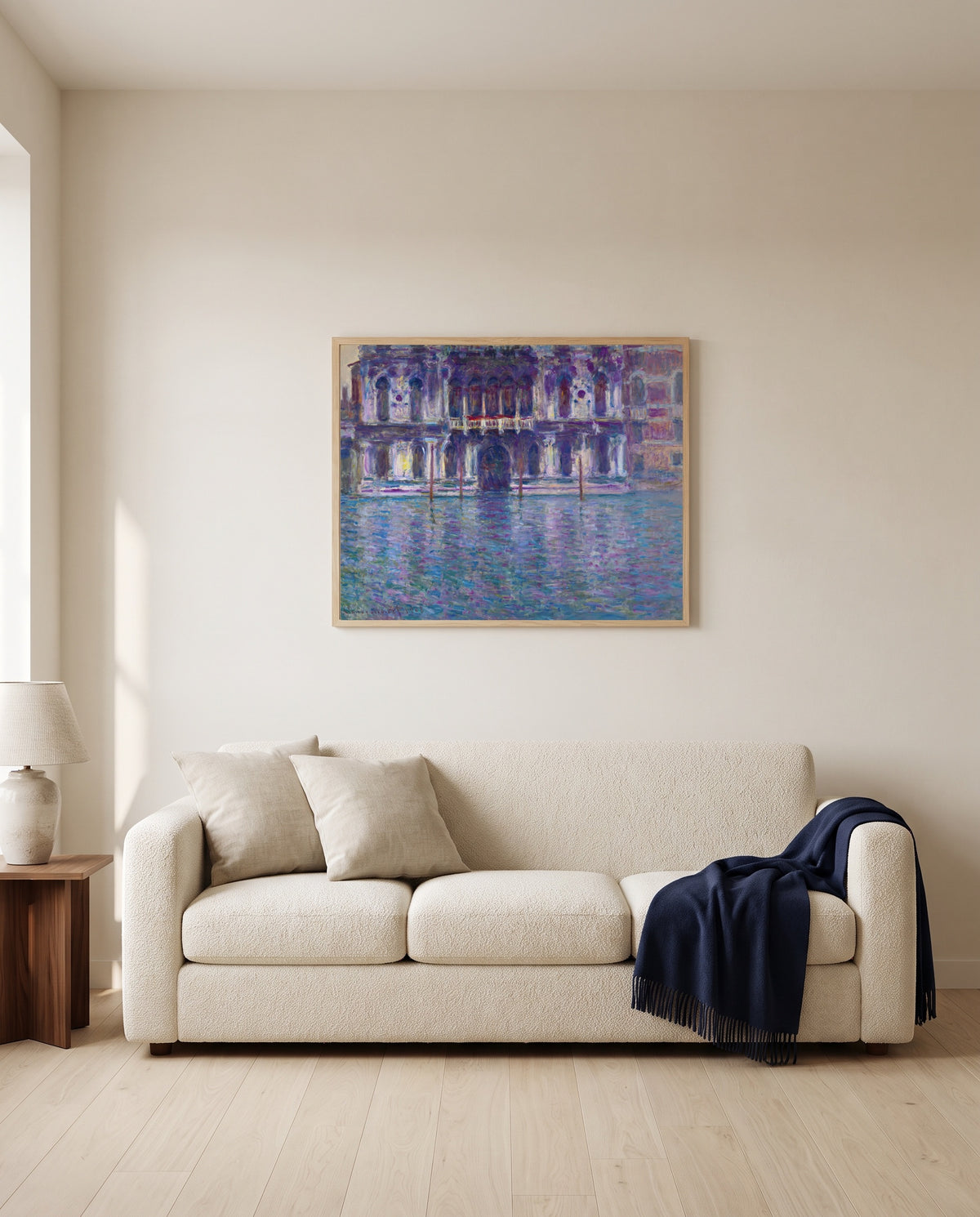 The Palazzo Contarini by Claude Monet framed in natural oak above a cream sofa in a warm living room