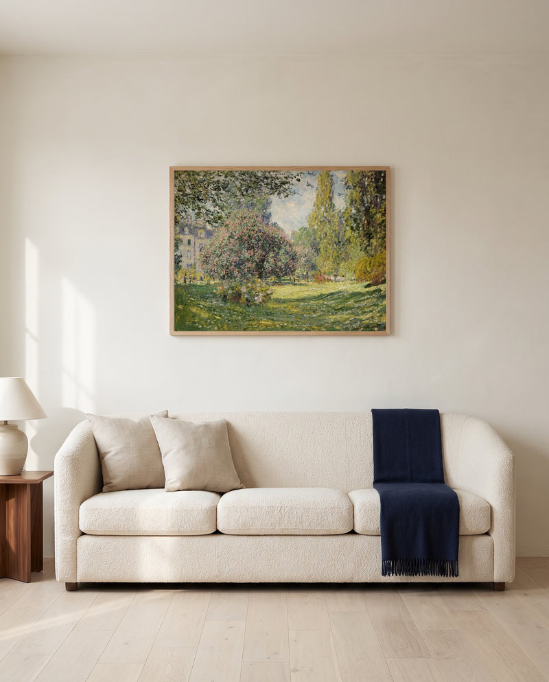 Landscape: The Parc Monceau by Claude Monet framed in natural oak above a cream sofa in a warm living room