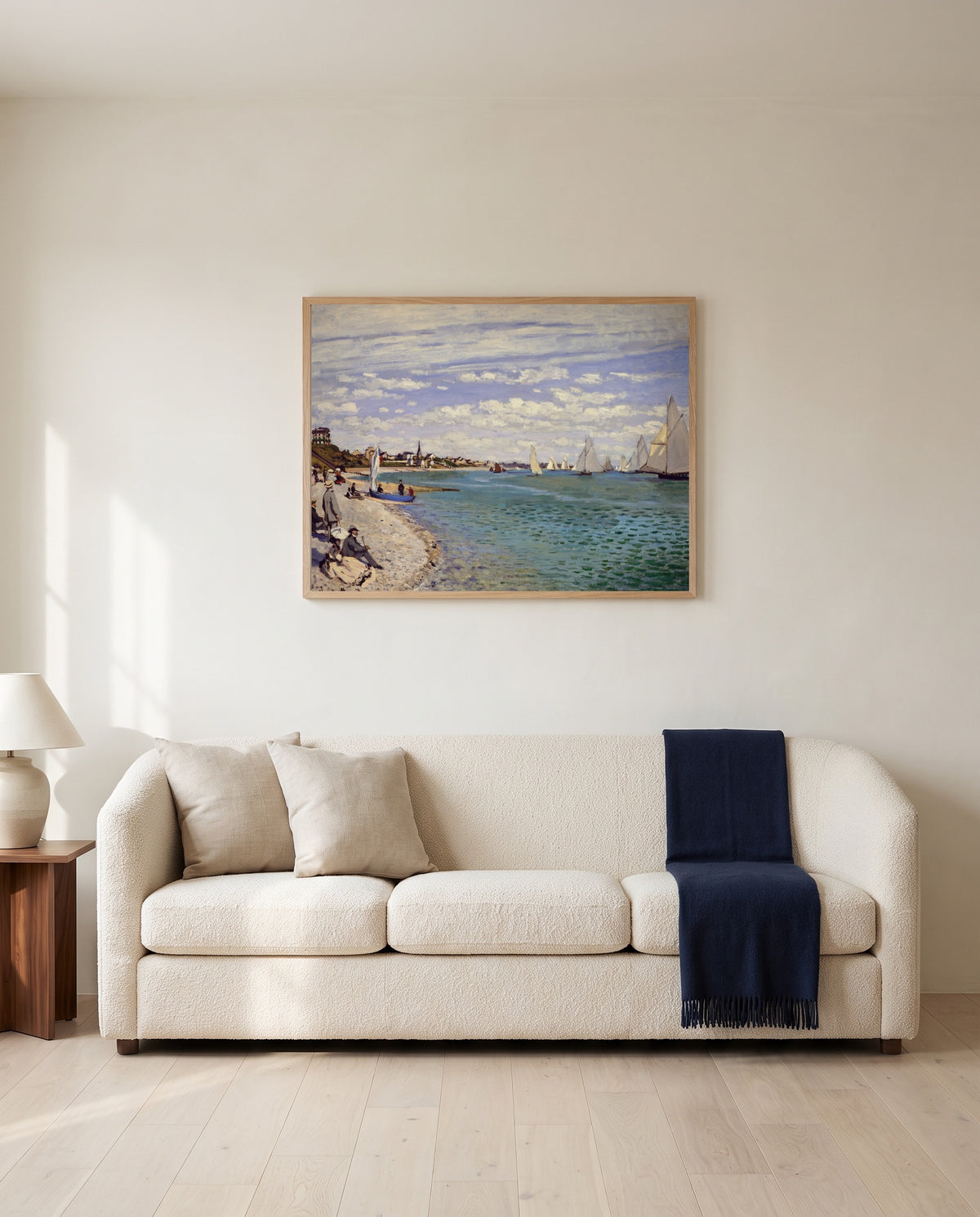 Regatta at Sainte-Adresse by Claude Monet framed in natural oak above a cream sofa in a warm living room