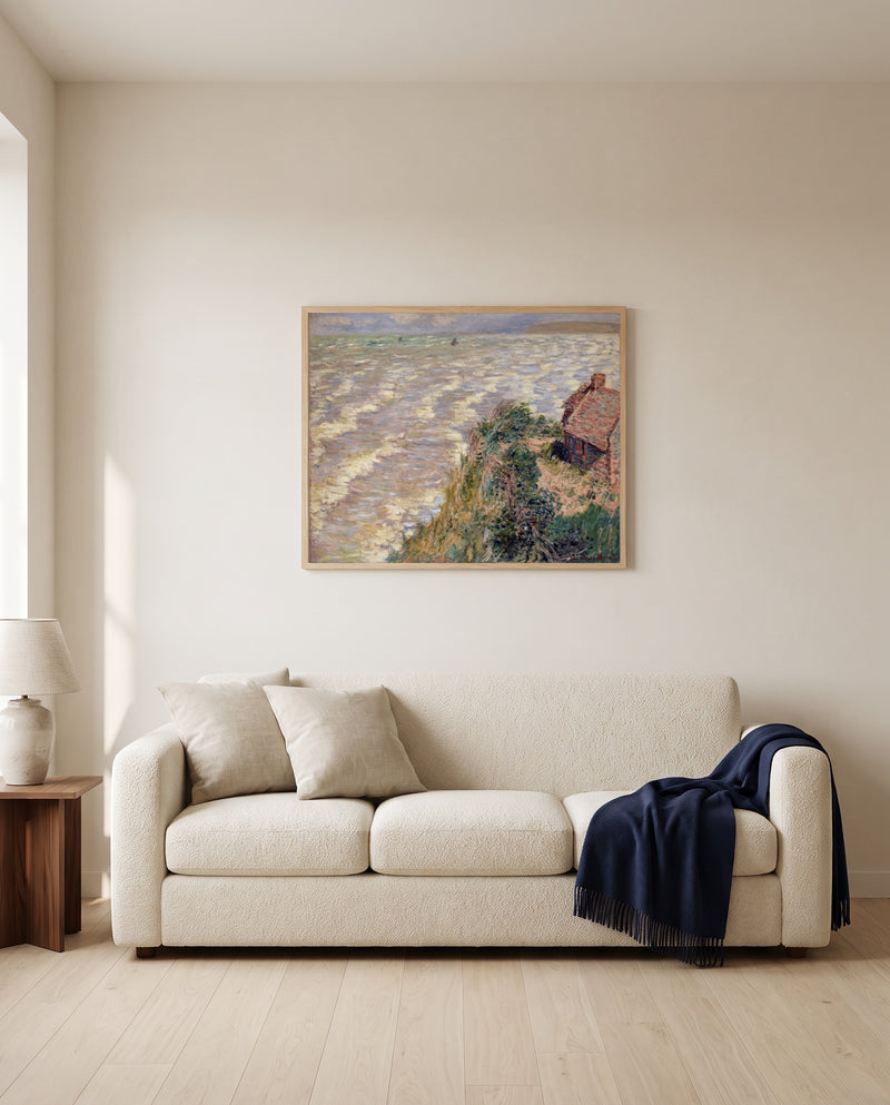 Rising Tide at Pourville by Claude Monet framed in natural oak above a cream sofa in a warm living room