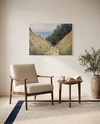 Road at La Cavée by Claude Monet as a stretched canvas above a linen lounge chair in a reading corner