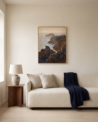 Rocks at Belle-Isle by Claude Monet framed in natural oak above a cream sofa in a warm living room