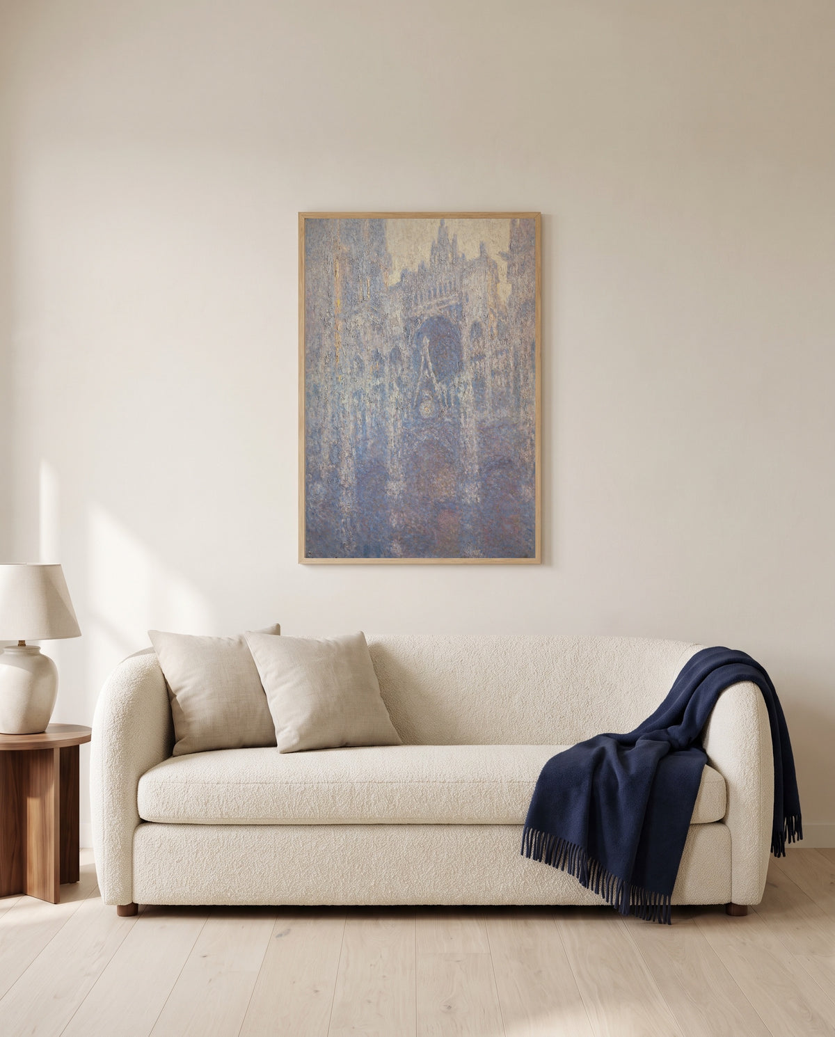 Rouen Cathedral, Morning by Claude Monet framed in natural oak above a cream sofa in a warm living room