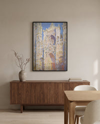 Rouen Cathedral, Sunlight by Claude Monet in a black frame above a walnut sideboard in a dining room