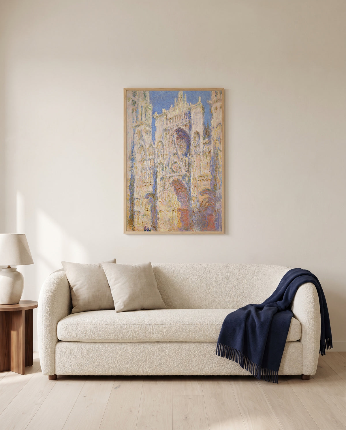 Rouen Cathedral, Sunlight by Claude Monet framed in natural oak above a cream sofa in a warm living room