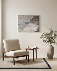 Rough Weather at Étretat by Claude Monet as a stretched canvas above a linen lounge chair in a reading corner