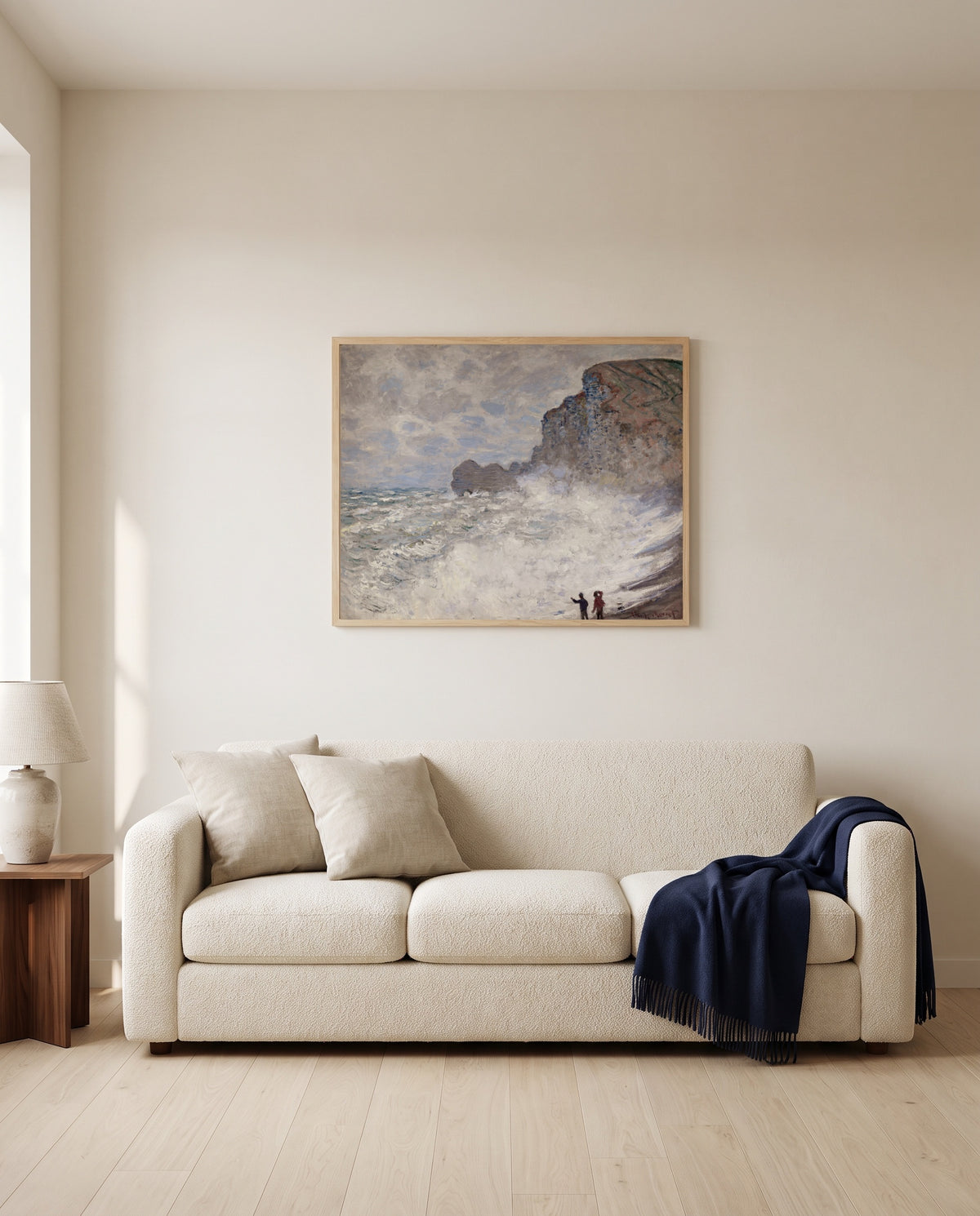 Rough Weather at Étretat by Claude Monet framed in natural oak above a cream sofa in a warm living room