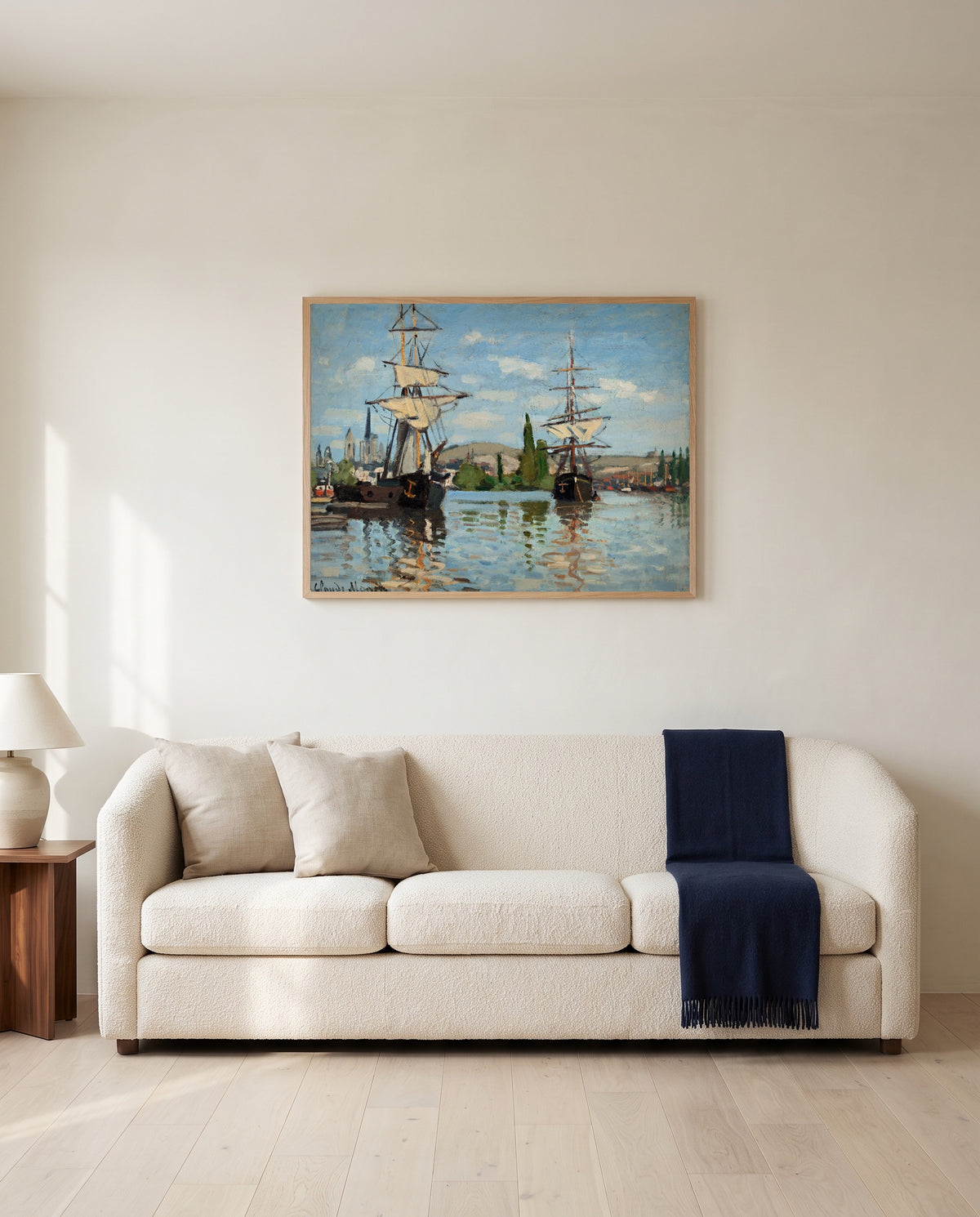 Ships Riding on the Seine at Rouen by Claude Monet framed in natural oak above a cream sofa in a warm living room