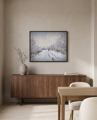 Snow at Argenteuil by Claude Monet in a black frame above a walnut sideboard in a dining room