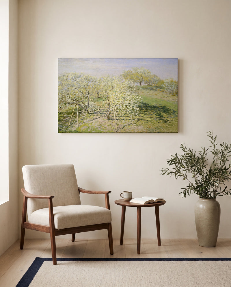 Spring, Fruit Trees in Bloom by Claude Monet as a stretched canvas above a linen lounge chair in a reading corner