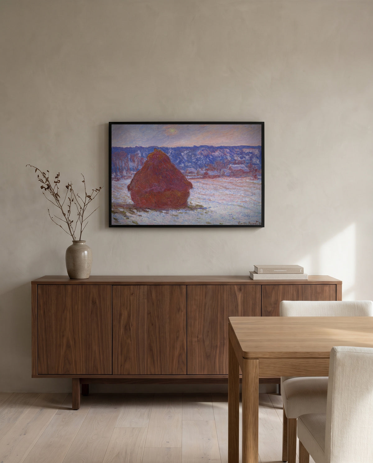 Stack of Wheat, Overcast by Claude Monet in a black frame above a walnut sideboard in a dining room