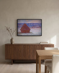 Stack of Wheat, Overcast by Claude Monet in a black frame above a walnut sideboard in a dining room