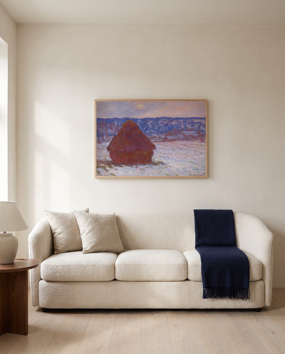 Stack of Wheat, Overcast by Claude Monet framed in natural oak above a cream sofa in a warm living room