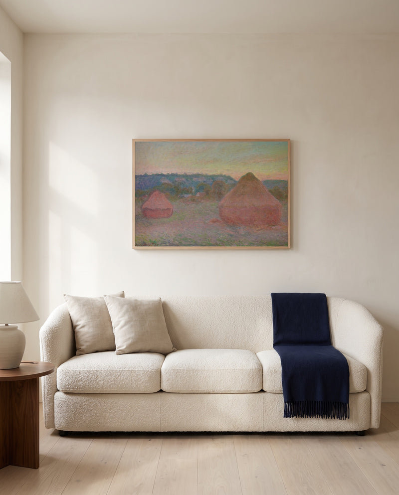 Stacks of Wheat, End of Day by Claude Monet framed in natural oak above a cream sofa in a warm living room