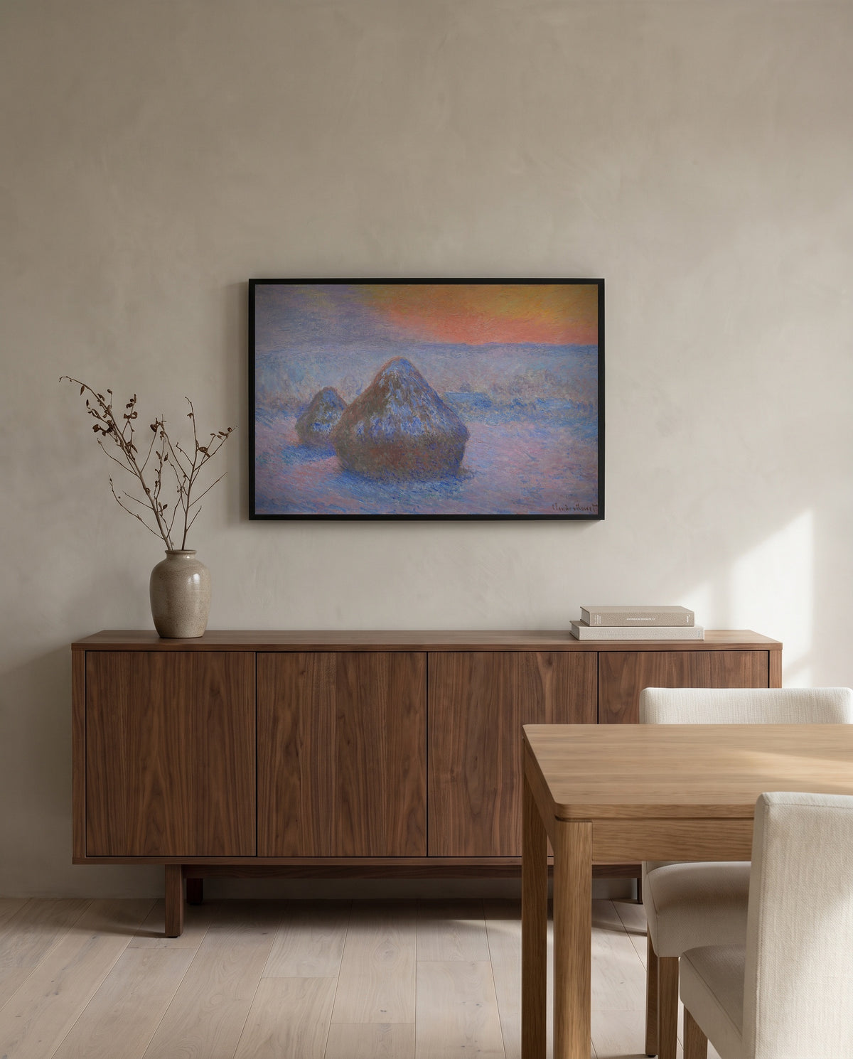 Stacks of Wheat, Snow Effect by Claude Monet in a black frame above a walnut sideboard in a dining room