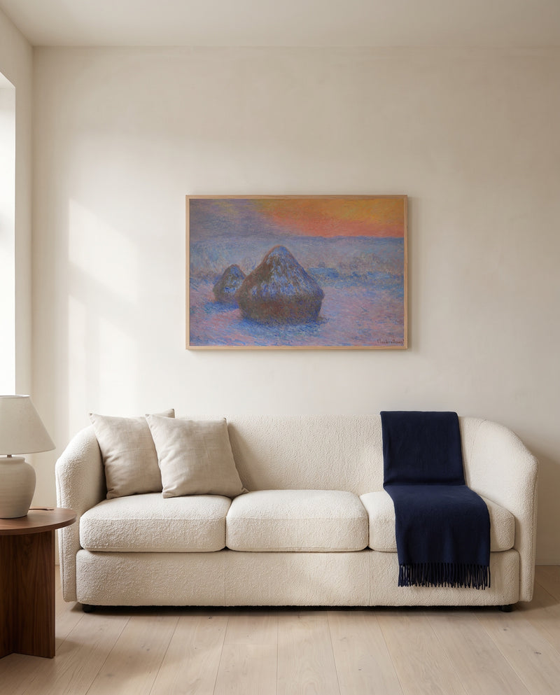 Stacks of Wheat, Snow Effect by Claude Monet framed in natural oak above a cream sofa in a warm living room