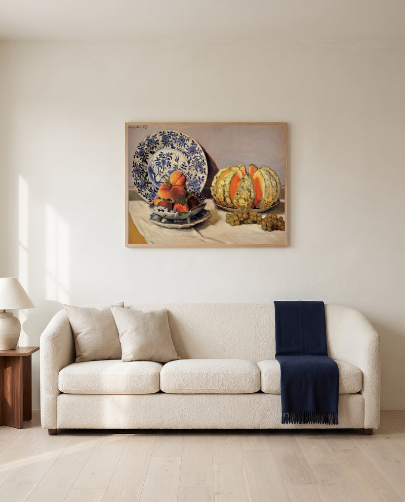 Still Life with Melon by Claude Monet framed in natural oak above a cream sofa in a warm living room