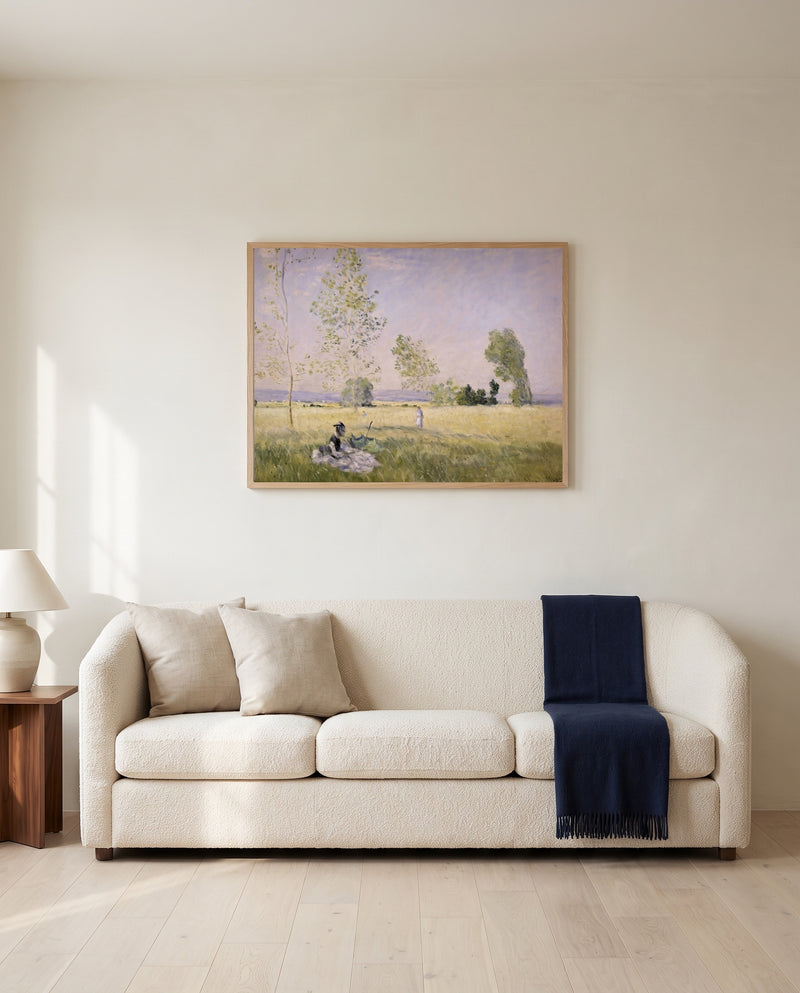 Summer, Meadow at Bezons by Claude Monet framed in natural oak above a cream sofa in a warm living room