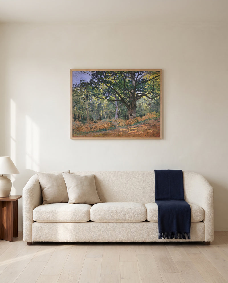 The Bodmer Oak by Claude Monet framed in natural oak above a cream sofa in a warm living room