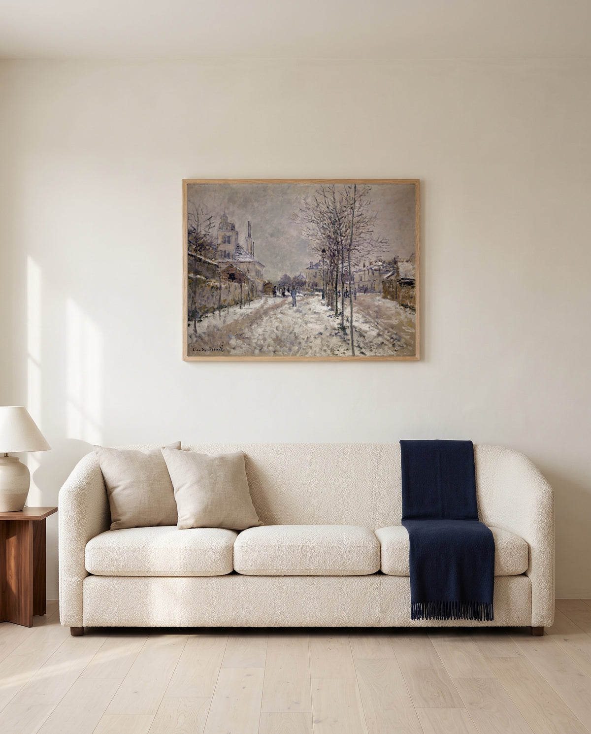 Boulevard de Pontoise, Snow by Claude Monet framed in natural oak above a cream sofa in a warm living room