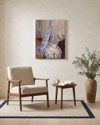 The Cradle by Claude Monet as a stretched canvas above a linen lounge chair in a reading corner